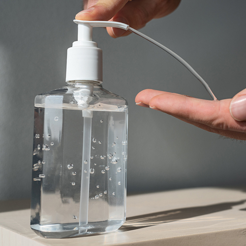 a man is sanitizing his hand with anti bacterial hand sanitizer.