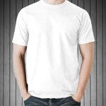 A man in a white branded t-shirt stands with his hand in his pants pocket.