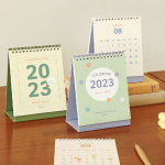 Three different calendars are placed side by side on a table.