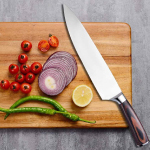 A knife is placed on a cutting board where an onion and a lemon are beautifully cut.