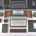 On a desk, there are a mouse, keyboard, and a small artificial plant neatly arranged.
