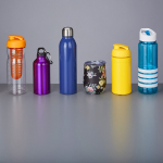 Different-colored bottles are arranged in a line in an orderly fashion. They are used as drinkware.