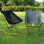 Two foldable chairs used as outdoor leisure promotional products placed on a green lawn.