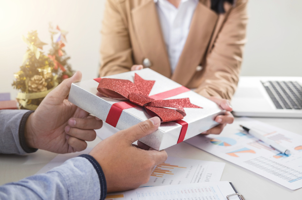 An employee handling receiving gift from his senior.