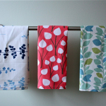 The kitchen towels are hanging on the wall.