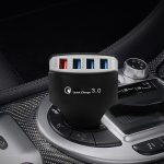 A multi-port portable charger is plugged into the charging port of a car, with the company's logo printed on it for promotional purposes.