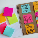 Different-colored sticky notes are placed together, with some of them having writing on them.