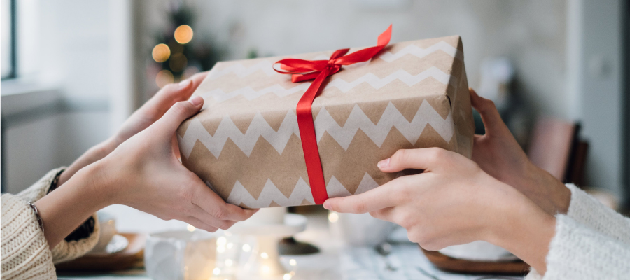 An senior company employee is giving a gift to another employee.