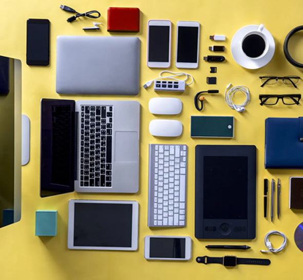 Various technology promotional products, including a laptop, chargers, tablet, cell phone, mouse, and keyboard, are placed together.