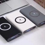 Three wireless power banks, each with the company logo printed on them, are placed together.